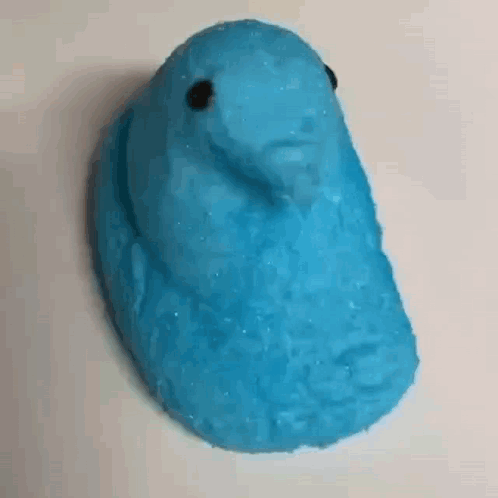 A Close Up Of A Blue Peeps Easter Bunny On A Table . GIF