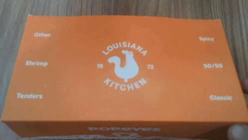 A Close Up Of A Box Of Donut Holes With The Word Donut In White Letters GIF