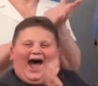 A Close Up Of A Boy Making A Funny Face With His Mouth Open And His Hands In The Air . GIF