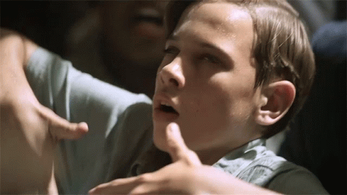 A Close Up Of A Boy 'S Face With A Hand On His Chest GIF