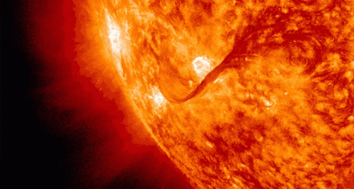 A Close Up Of A Bright Orange Sun With A Dark Background GIF