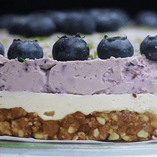A Close Up Of A Cake With Blueberries On Top Of It GIF