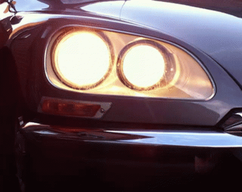 A Close Up Of A Car 'S Headlights That Are Lit Up GIF