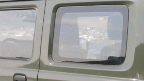 A Close Up Of A Car Window With A Reflection Of A City GIF