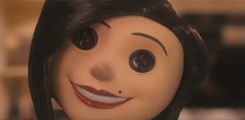A Close Up Of A Cartoon Character 'S Face With Buttons On It 'S Eyes . GIF