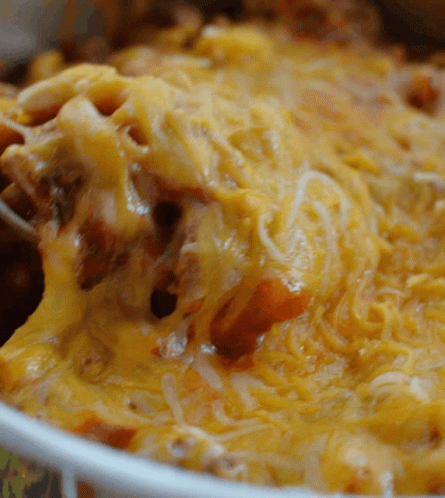 A Close Up Of A Casserole Dish Filled With Cheese And Meat GIF