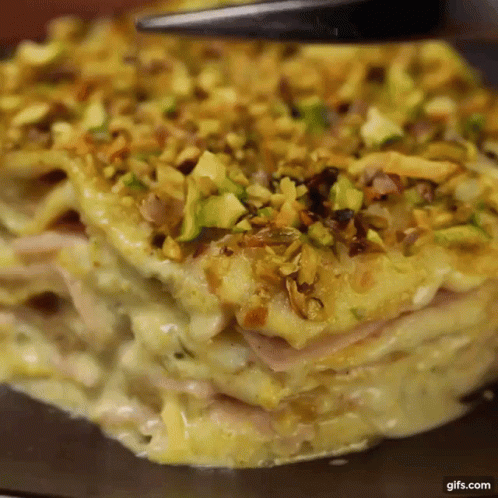 A Close Up Of A Casserole Dish With Pistachios On Top Of It GIF