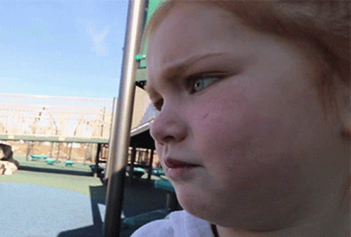 A Close Up Of A Child 'S Face In A Park GIF