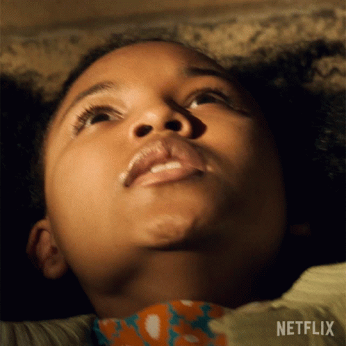 A Close Up Of A Child 'S Face With A Netflix Logo Behind Her GIF