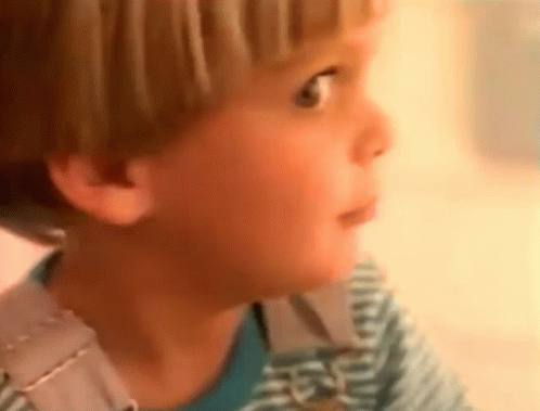 A Close Up Of A Child 'S Face With A Striped Shirt On GIF