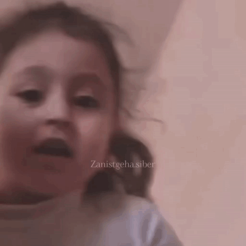 A Close Up Of A Child 'S Face With The Words Zanistgeha.siber On The Bottom Right GIF