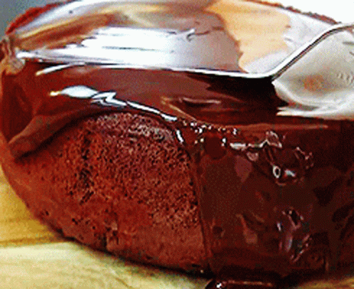 A Close Up Of A Chocolate Cake With A Spoon Sticking Out Of It GIF