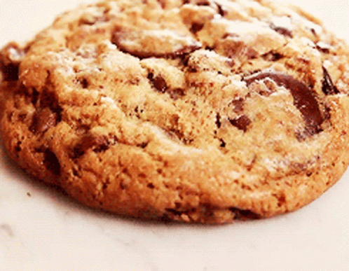 A Close Up Of A Chocolate Chip Cookie On A Plate GIF