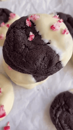 A Close Up Of A Chocolate Cookie With White Frosting And Candy Canes On Top . GIF