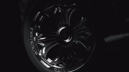 A Close Up Of A Chrome Wheel With The Letter H On The Center GIF