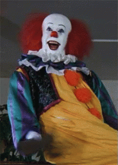 A Close Up Of A Clown With Red Hair And White Face GIF