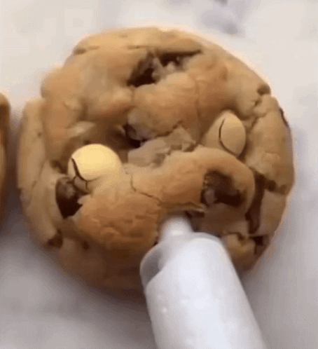 A Close Up Of A Cookie Being Frosted With White Frosting GIF