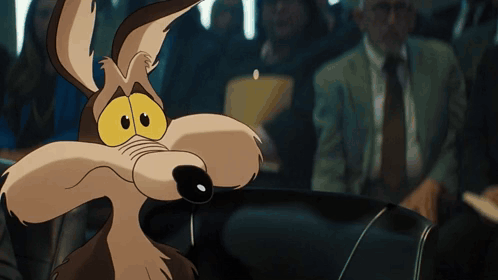 a close up of a coyote with a man in a suit behind him