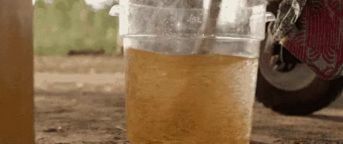 A Close Up Of A Cup Of Liquid With A Straw . GIF