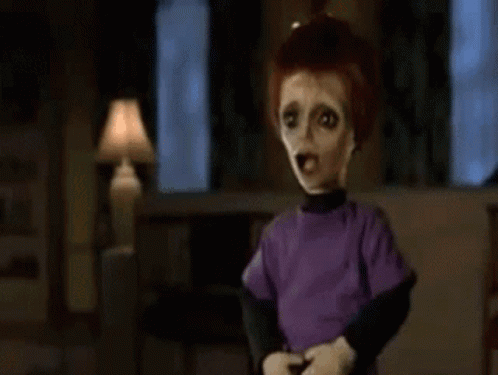 A Close Up Of A Doll 'S Face In A Dark Room With A Blurred Background . GIF