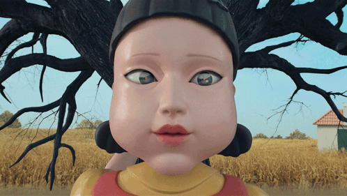A Close Up Of A Doll 'S Face With A House In The Background GIF