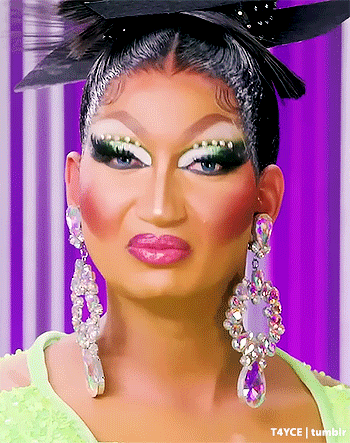 Drag Queen With Earrings And Feathered Hat GIF