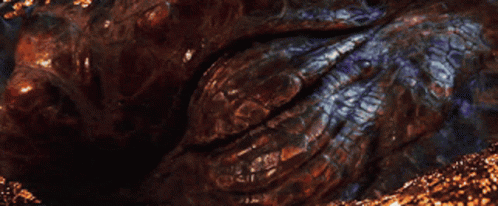A Close Up Of A Dragon 'S Eye With A Glowing Orange Pupil GIF