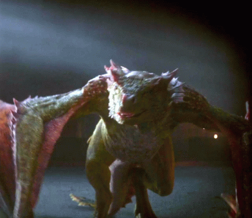A Close Up Of A Dragon 'S Face And Wings In The Dark GIF