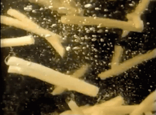 A Close Up Of A Few Pieces Of Cheese On A Black Surface GIF