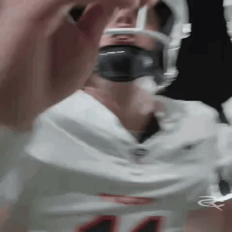 a close up of a football player wearing a helmet and headphones .