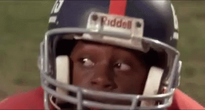 A Close Up Of A Football Player Wearing A Helmet And Looking At The Camera . GIF