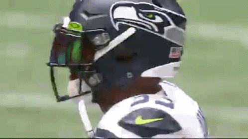 A Close Up Of A Football Player Wearing A Seahawks Helmet And Visor . GIF