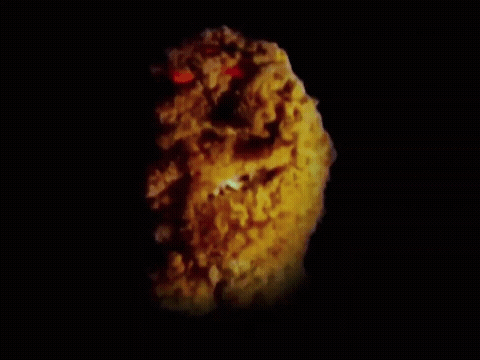 A Close Up Of A Fried Chicken Nugget With Red Eyes GIF