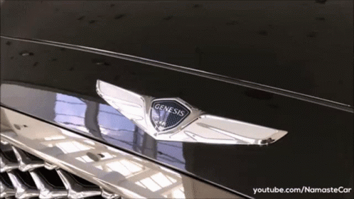 A Close Up Of A Genesis Logo On A Black Car GIF