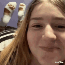 A Close Up Of A Girl 'S Face With A Paw Print On Her Socks . GIF