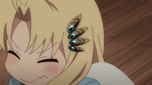 A Close Up Of A Girl 'S Face With A Peacock Feather On Her Hair GIF