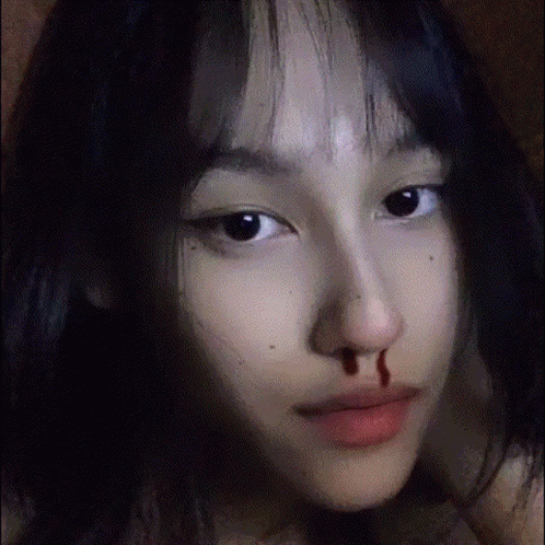 A Close Up Of A Girl 'S Face With Blood On Her Nose . GIF