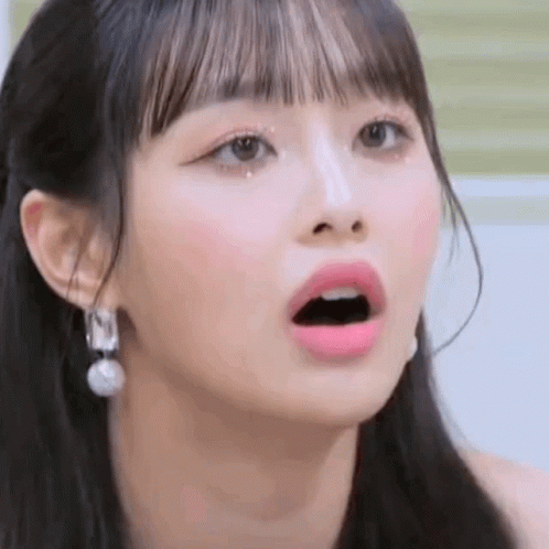 A Close Up Of A Girl 'S Face With Her Mouth Open And Earrings . GIF