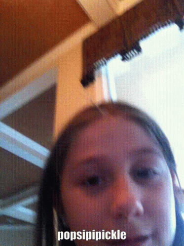 A Close Up Of A Girl 'S Face With The Words Popsipipickle On The Bottom Right GIF