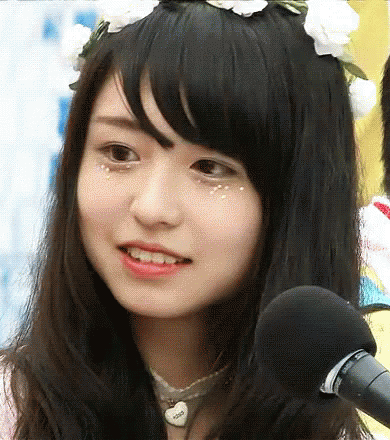 A Close Up Of A Girl Wearing A Flower Crown And A Microphone GIF
