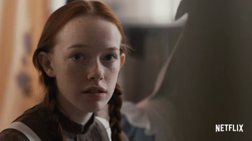 A Close Up Of A Girl With Red Hair And A Netflix Logo In The Background GIF