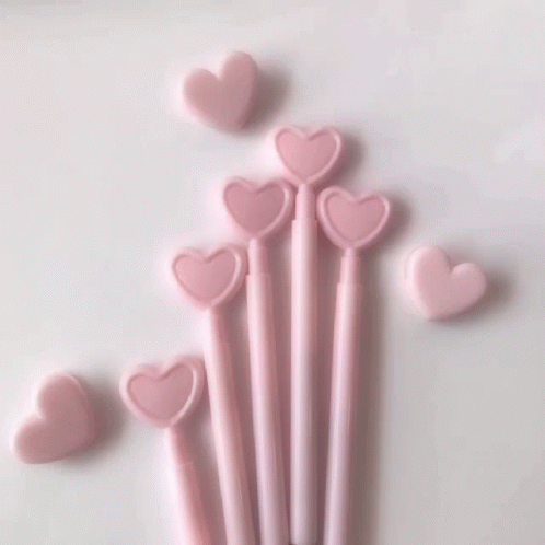 A Close Up Of A Glass Of Pink Liquid With Heart Shaped Ice Cubes GIF
