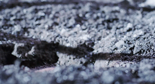 A Close Up Of A Gray Surface With A Few White Spots GIF