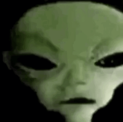 A Close Up Of A Green Alien 'S Face With Big Black Eyes . GIF