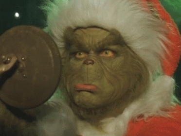 A Close Up Of A Grinch 'S Face With A Santa Hat On GIF