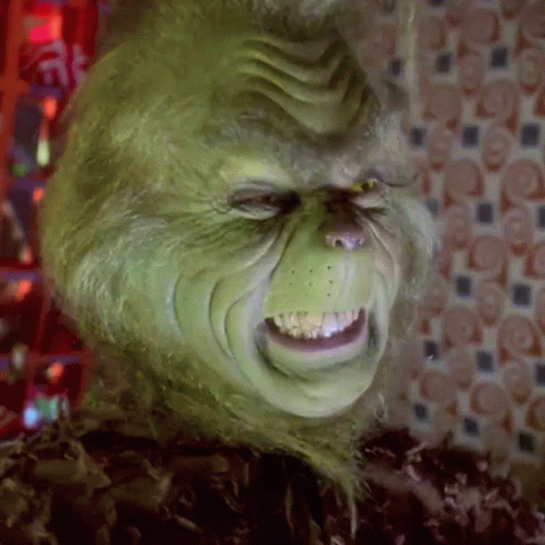 A Close Up Of A Grinch 'S Face With A Very Angry Expression . GIF