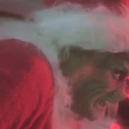 A Close Up Of A Grinch 'S Face With Glowing Red Eyes GIF