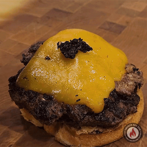 A Close Up Of A Hamburger On A Bun With Smoked Red Hot Written On The Bottom GIF