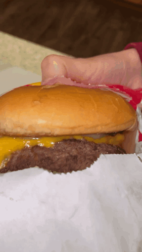 A Close Up Of A Hamburger With A Bun And Cheese GIF