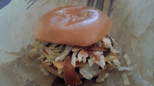 A Close Up Of A Hamburger With Lettuce And Bacon On It GIF